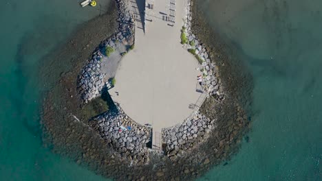 vertical-drone-shot-of-a-beach-in-Andora,-Liguria
