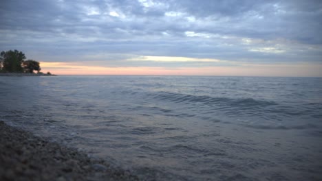 Beautiful-Waves-Splashing-Gently-Onto-The-Shore-During-Sunset---Wide-Shot
