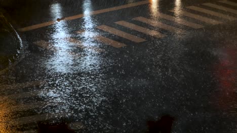 Car-headlights-reflecting-on-a-crossroads-in-heavy-rain