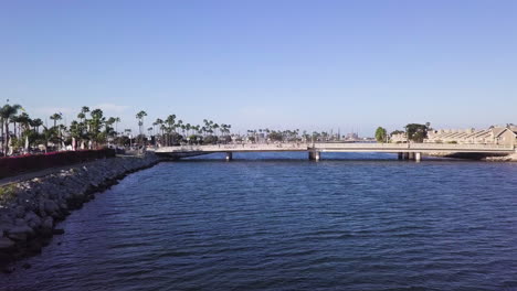 Flying-towards-a-bridge-over-the-San-Gabriel-River-in-Long-Beach,-California
