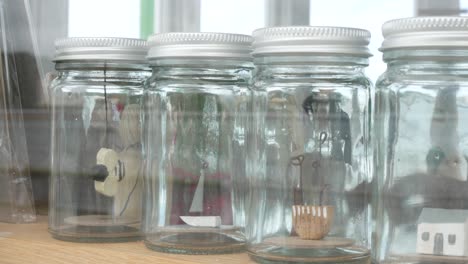 Glass-jars-filled-with-important-life-choices-wooden-models-reflections-in-window