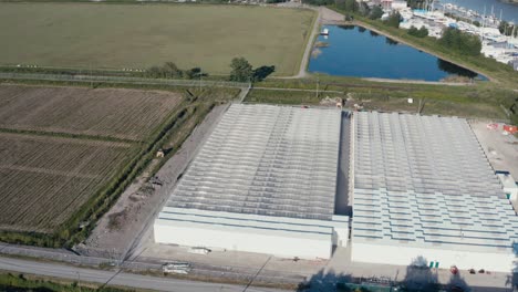 Aerial-birds-eye-view-fly-over-bobwire-Givernment-regulated-secure-cannabis-farming-pricessing-facility-greenhouse-next-to-winery-cranberry-farm-in-Richmond-BC-Canada-connected-to-Fraser-RIver-Port