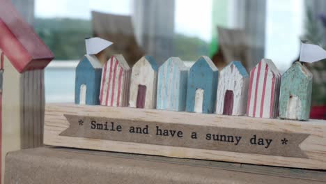 Smile-happy-quote-on-tiny-wooden-property-model-buildings-real-estate-conceptual-dolly-left