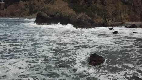 Aerial-waves-crashing-against-beach-in-Oregon