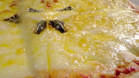 Toma-Macro-Cortando-Pizza-Con-Queso-Y-Salsa-De-Tomate