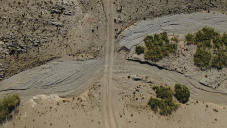 Top-down-lowering-aerial-view-of-unpaved-road-in-desert-of-Morocco