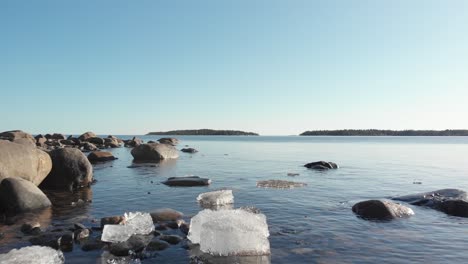 Low-drone-shoot-of-melting-ice-floating-in-cold-water-in-north-of-Sweden