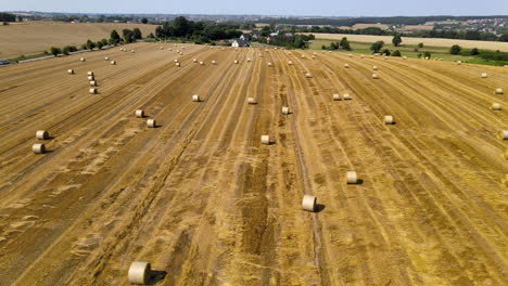 Aerial-tracking-shot-of-fields-of-hay-bales-in-the-Polish-countryside