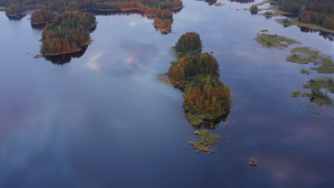 Aerial-video-of-beautiful-calming-lake-scenery-with-clouds-reflecting-on-water-by-golden-hour