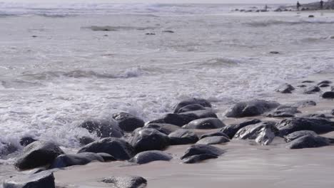 Stones-And-Rocks-In-The-Sand-Polished-Smooth-The-Ocean-Waves---Beach-In-Crescent-Head,-NSW---close-up
