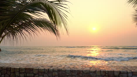 Blick-Auf-Das-Meer-Mit-Exotischem-Sonnenuntergang-Durch-Palmblätter