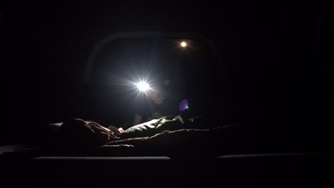 Boy-reading-in-the-dark-wearing-a-headlamp-to-light-up-the-darkness
