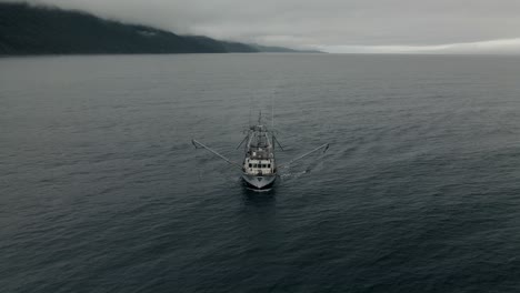 Un-Barco-De-Pesca-Solitario,-Arrastrero-Navegando-En-El-Mar-Azul-Profundo-En-Quebec,-Canadá-Bajo-El-Cielo-Nublado