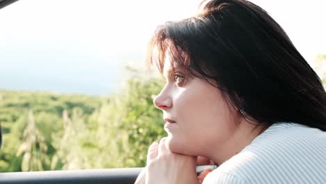 Young-woman-with-tired-eyes-watching-the-passing-countryside-on-the-journey-home