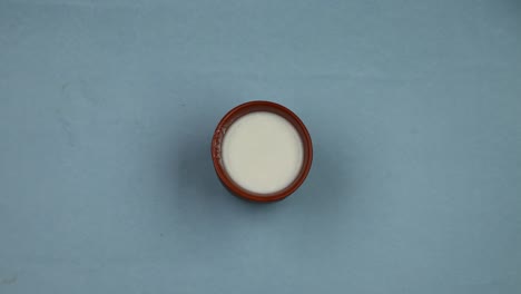 4K-UHD-Stop-motion-mud-glass-filling-with-s-fresh-milk-on-blue-table-background