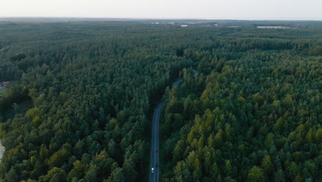 Aerial-orbit-above-beautiful-highway-transportation-through-remote-coniferous-forest