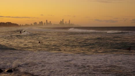 Surfen-Bei-Sonnenuntergang---Surfer-Reiten-Wellen-Während-Des-Goldenen-Sonnenuntergangs-In-Gold-Coast,-Australien---Surfers-Paradies