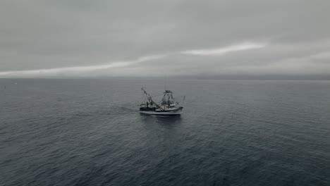 Fishing-Boat-Sailing-At-Sea-On-A-Cloudy-Morning---Wide-Shot