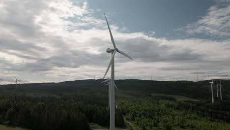 Wind-Turbines-Generating-Renewable-Energy-On-The-Lush-Field-In-Canada-On-A-Sunny-Day---elevated-panning-shot