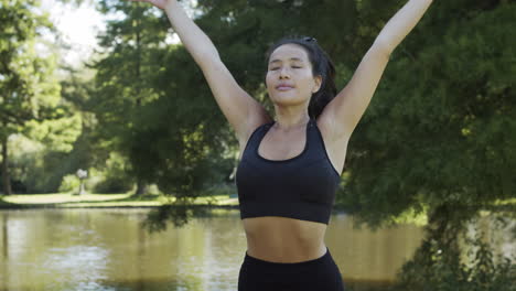 Young-woman-doing-ending-yoga-exercise-and-looking-into-camera