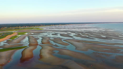 Cape-Cod-Bay-Aerial-Drone-Footage-of-Beach-at-Low-Tide-with-People-Walking,-Sand-Bars-and-Puddles-During-Golden-Hour