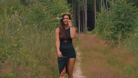 A-Beautiful-Lady-In-Sexy-Black-Dress-Smiling-As-She-Walks-Backward-On-The-Trail-At-The-Lush-Forest-In-Olomouc,-Czech-Republic---wide-shot---slow-motion