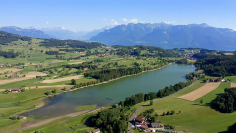 Clear-And-Blue-Stretch-Of-Bret-Lake-In-The-Swiss-Countryside-With-Idyllic-Alpine-Landscape-In-Background