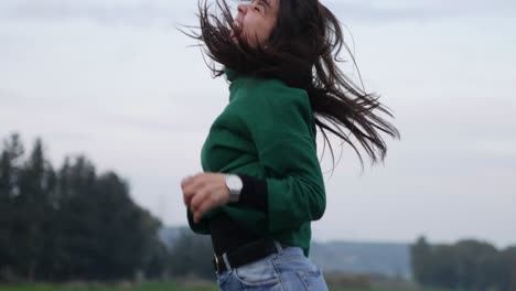 An-excited-young-woman-jumps-for-joy-outdoors-on-a-brisk-Autumn-day