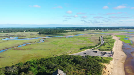 Cape-Cod-Aerial-Drone-Footage-of-Marsh-and-Beach-Front-Houses-at-Low-Tide-with-People-and-Tall-Green-Grass