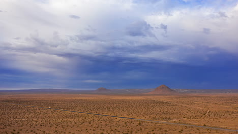 Luftüberschreitung-Der-Mojave-Wüstenlandschaft,-Berggipfel-Und-Verkehr-Entlang-Einer-Geraden-Autobahn