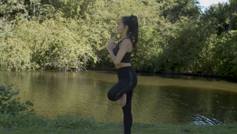 Young-woman-standing-in-tree-pose-yoga-exercise