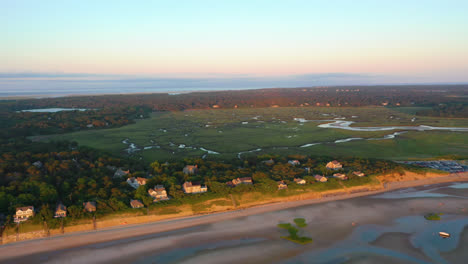 Cape-Cod-Bay-Aerial-Drone-Footage-of-Beach-Front-Houses-and-Marsh-at-Low-Tide-During-Golden-Hour-with-Seagulls-Flying-Below