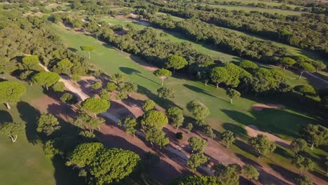 Aerial-tilt-down-shot-of-a-golf-course-in-the-south-of-Spain-with-the-sea-in-the-horizon