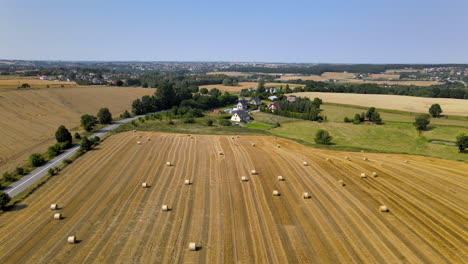 Crane-up-aerial-shot-of-fields-of-hay-bales-in-northern-european-countryside