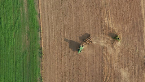 Farming-Tractor-on-Agricultural-Dirt-Field---Aerial-Topdown-Drone-View
