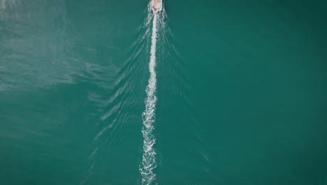 Top-down-aerial-view-revealing-boat-sailing-on-calm-lake