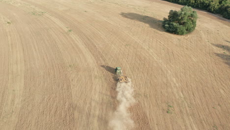 Agricultural-Tractor-Plowing-Farm-Land---Descending-Aerial-Tilt-Up-Reveal