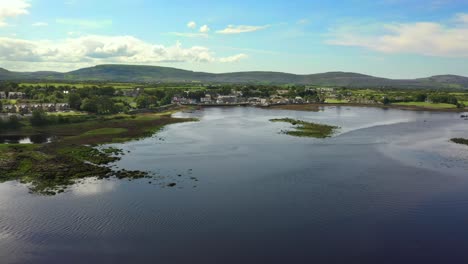 Kinvara,-Galway,-Irlanda,-Agosto-De-2020,-Drone-Volando-Sobre-El-Agua-Mientras-Empuja-Hacia-El-Pueblo-De-Pescadores