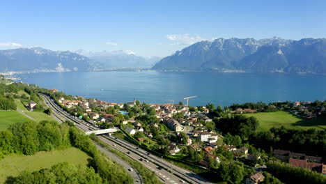 Cars-Driving-On-Highway-A9-Near-Chexbres-Village,-Overlooking-The-Beautiful-Lake-Leman-And-Mountain-Alps-On-The-Background,-Switzerland---aerial-drone