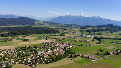 Forel-Village-In-The-Swiss-Countryside-Surrounded-By-The-Lush-Green-Fields-And-Meadows-During-Summer-In-Vaud,-Lavaux-Oron,-Switzerland---aerial-drone