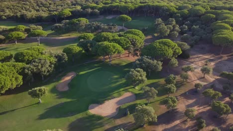 Aerial-ascending-shot-of-a-hole-surrounded-by-sand-bunkers-in-a-mediterranean-golf-course