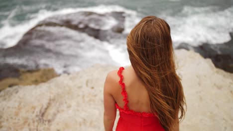 Rückansicht-Eines-Mädchens-In-Rotem-Kleid-Mit-Langen-Haaren,-Das-Die-Wellen-Des-Ozeans-Beobachtet---östliche-Vororte,-Sydney,-NSW,-Australien
