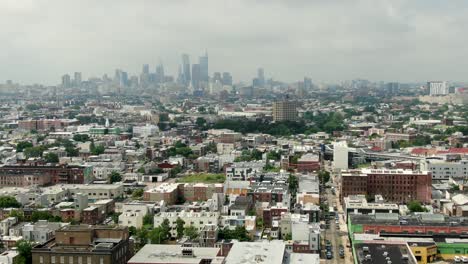 Kensington-and-North-Philadelphia-neighborhoods-with-Philly-skyline-in-distance,-aerial-establishing-shot-of-poor-communities,-homes-and-housing-projects,-summer-day