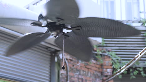 Retro-style-ceiling-fan-spinning-on-hot-day-in-outdoor-venue