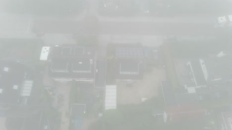 Top-down-aerial-of-suburban-neighbourhood-covered-in-mist