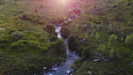 Aerial-low-shot-over-the-course-of-a-river-in-the-Grand-Teton-Park-with-sun-beams-in-the-top-of-the-shot