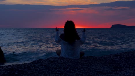 Silhouette-Einer-Frau,-Die-Sich-Auf-Die-Yoga-Pose-Konzentriert,-Die-Während-Des-Farbenprächtigen-Sonnenuntergangs-Am-Strand-Trainiert