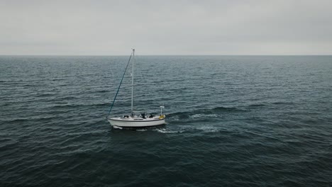 Low-angle-aerial-passing-by-sailboat-at-sea
