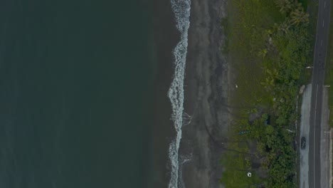 Top-down-Shot-Of-Dark-Blue-Sea-With-Waves-Splashing-On-The-Sandy-Shore-In-The-Philippines---Aerial-Drone-Shot