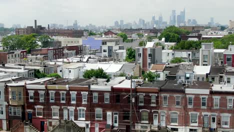 Aerial-establishing-shot-of-Kensington-neighborhood,-Philadelphia-skyline-on-horizon-on-summer-day
